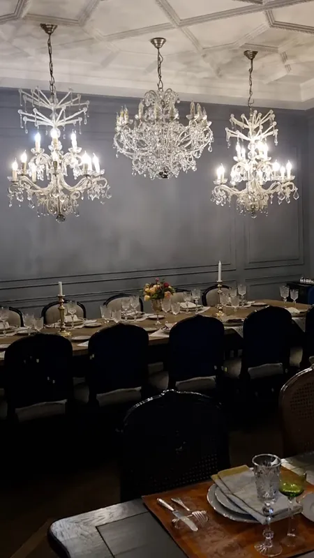 The banquet hall: a long table under three crystal chandeliers